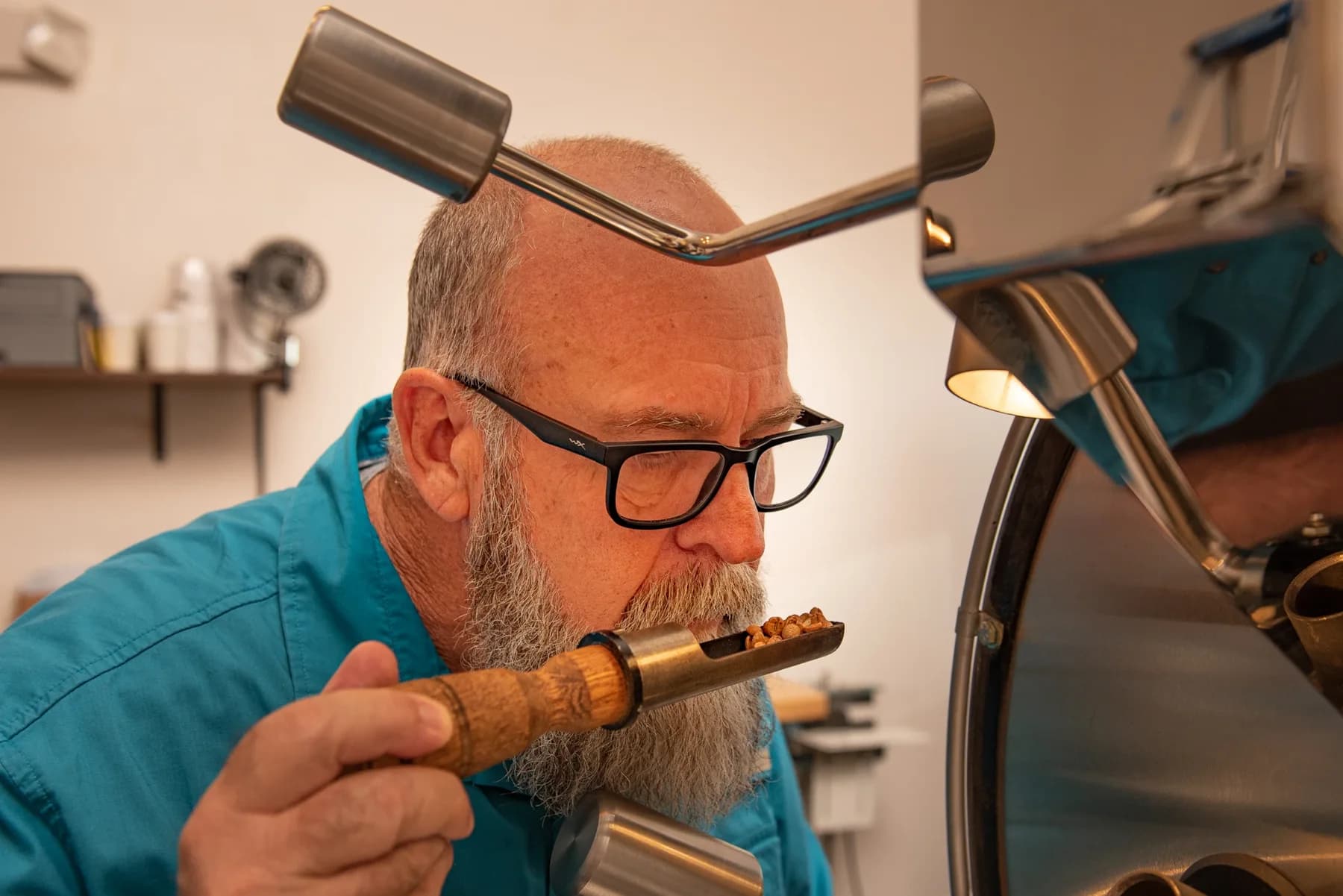 Michael Fewson assessing coffee beside the roaster